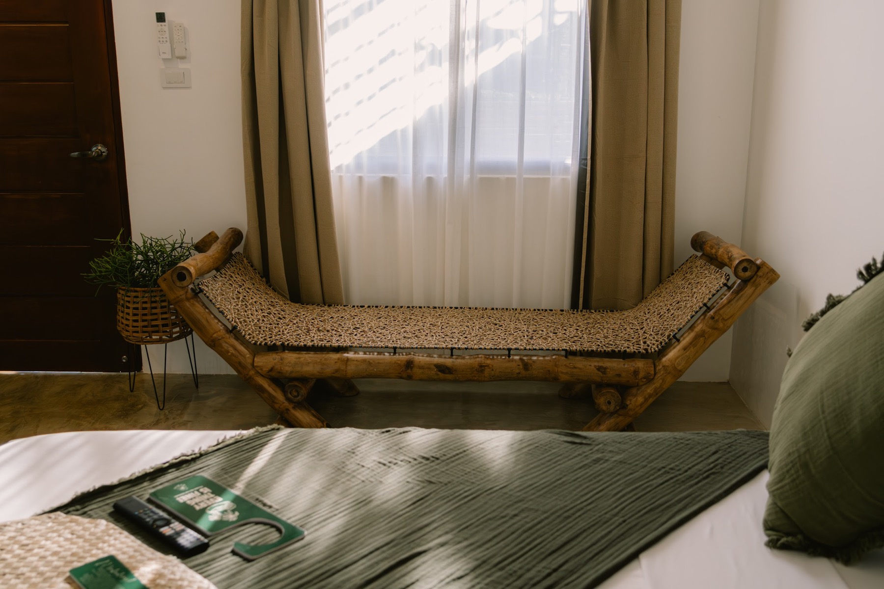 SAMPA's handcrafted bamboo daybed with a woven seat beside a sunlit window