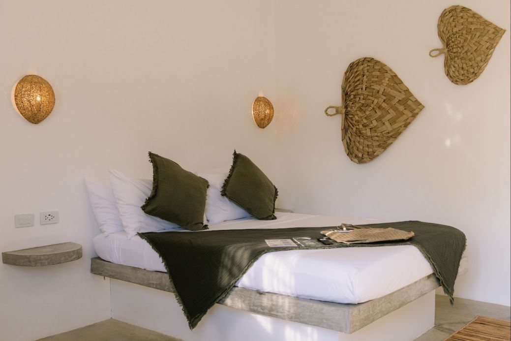 Deluxe Garden View room with queen bed, woven wall details and green cushions